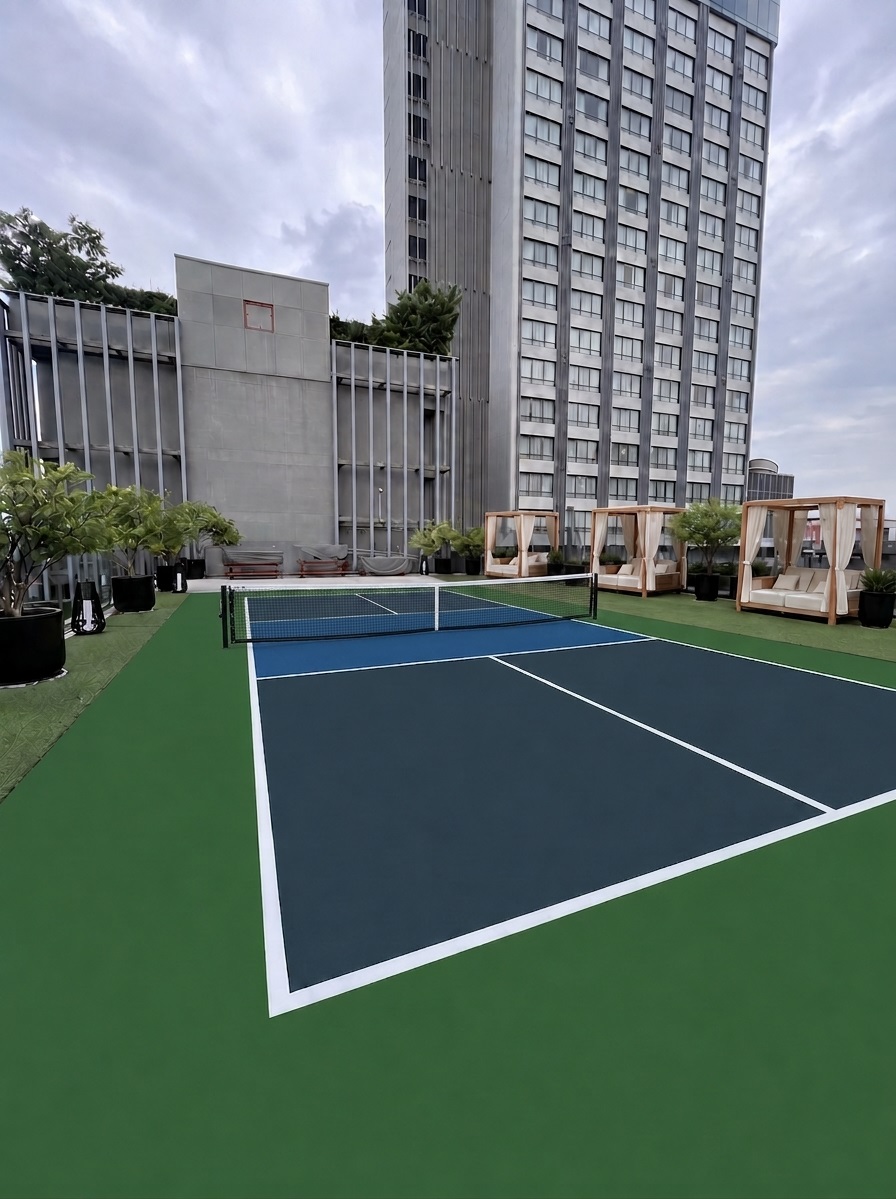 Rooftop acrylic pickleball court with blue playing surface and green surround